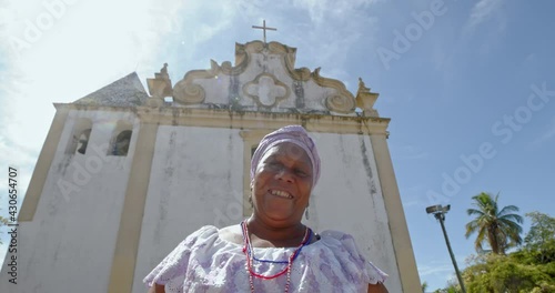 Happy Brazilian woman dressed in traditional Bahian costume in the historic center of Porto Seguro, Bahia, Brazil. 6K. photo