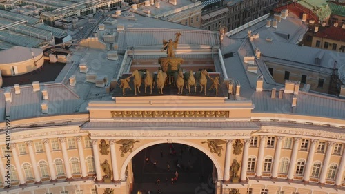 Aerial footage of Palace Square through a triumphal chariot, rear view, winged Nick, a symbol of military glory, over arch of the General Staff Building, the Aleksandr column, the Winter Palace