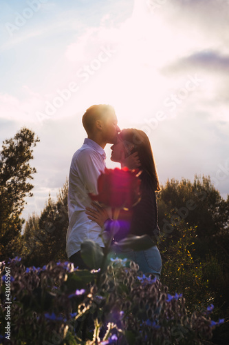 Couple kissing in sunset with a rose