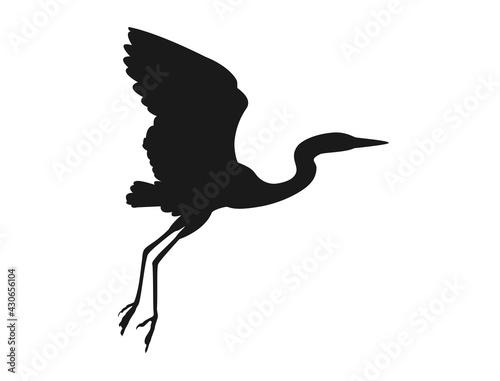 Silhouette of a crane flying low over the surface of the roof, ready to perch
