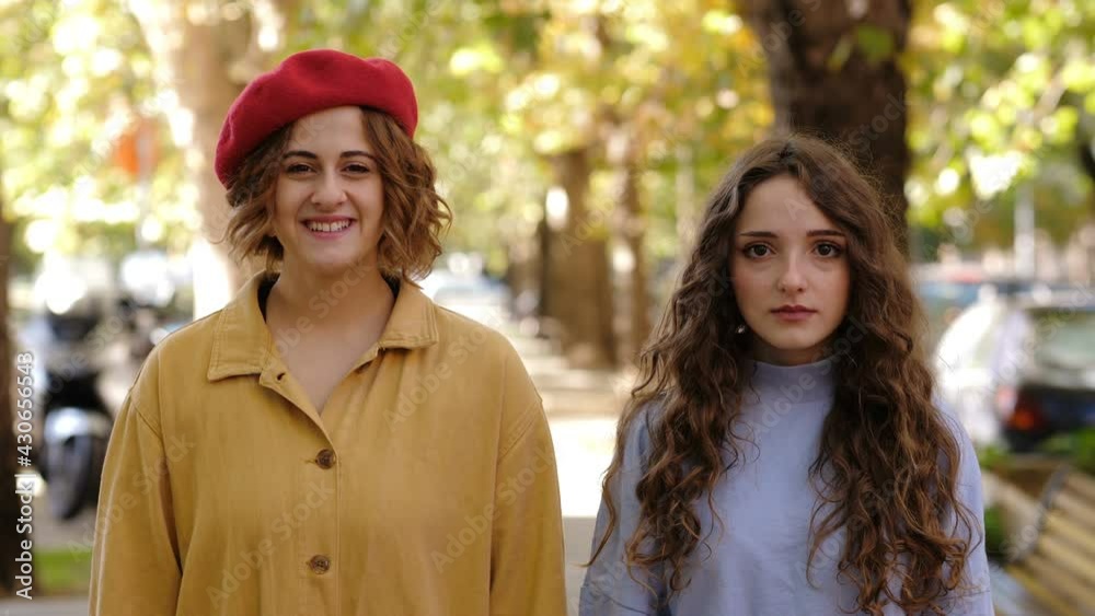 smile in turn - smiling girl and serious girl and vice versa stare at the camera smile in turn - smiling girl and serious girl and vice versa stare at the camera