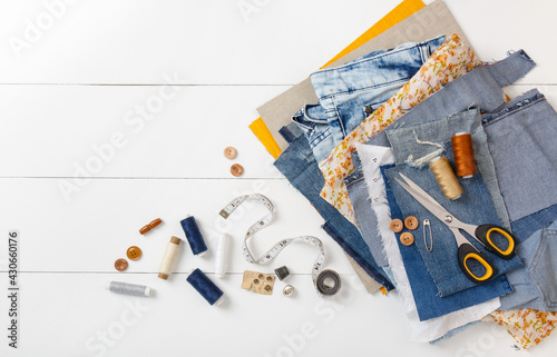 Wallpaper Mural Upcycle old denim garbage. Recycling old jeans. Old blue jeans cut pieces and sewing materials ready for recycling and scissors on white background. Circular economy. Zero waste banner with copy space Torontodigital.ca