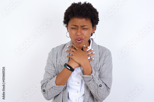 African American businesswoman with curly bushy hair wears  formal clothes over white background shouting suffocate because painful strangle. Health problem. Asphyxiate and suicide concept.