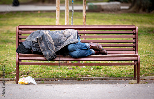 Homeless man sleeping on a bench