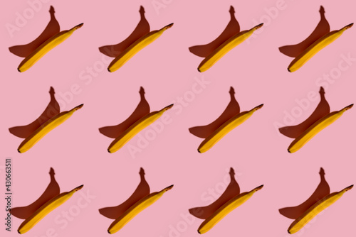 Colorful fruit pattern of fresh yellow bananas on a pink background. View from above.