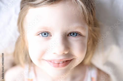 Portrait of little smiling girl with blue eyes
