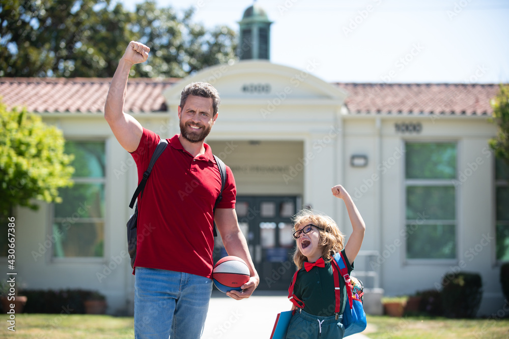 Obraz premium Teachers day. Parent and pupil of primary school go hand in hand. Teacher in t-shirt and cute schoolboy with backpack near school park.