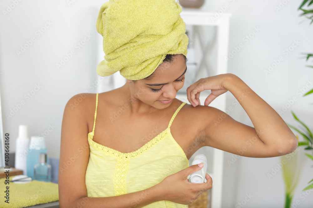 closeup on woman applying roller deodorant on underarm closeup on woman applying roller deodorant on underarm