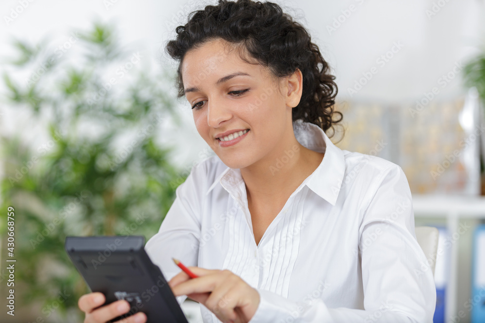 female with calculator in office female with calculator in office