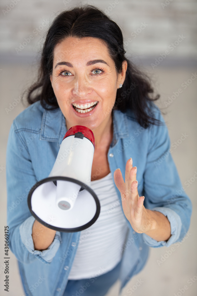 beautiful senior woman talking into a megaphone beautiful senior woman talking into a megaphone