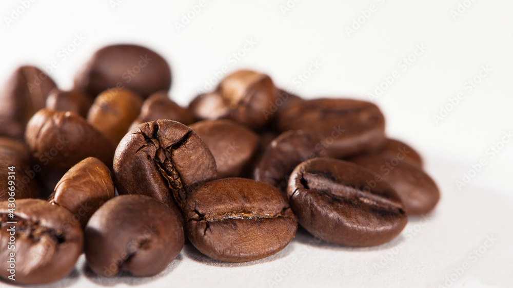 black coffee beans on a white background. Close-up of roasted coffee beans heap isolated on white. aromatic morning drink, invigorating black coffee. macro photo, close-up, on a white background black coffee beans on a white background. Close-up of roasted coffee beans heap isolated on white. aromatic morning drink, invigorating black coffee. macro photo, close-up, on a white background