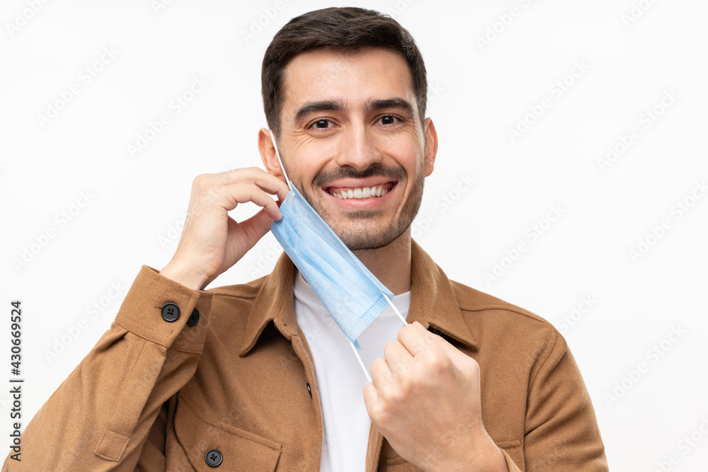 Mask off. Portrait of smiling young man after the end of pandemic. Concept of future, hope and recovery. Covid virus defeated, people are getting back to normal life