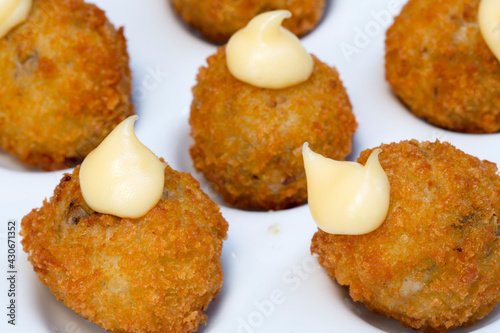 Homemade traditional Spanish croquettes or croquetas on a wooden table