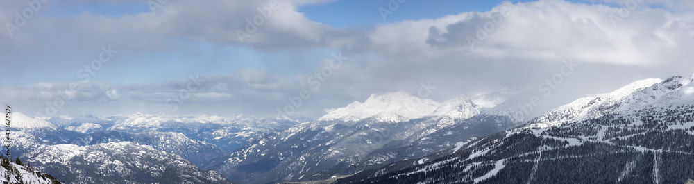 Whistler, British Columbia, Canada. Panoramic View of the Canadian Snow Covered Mountain Landscape during a cloudy and vibrant winter day. Nature Background Panorama