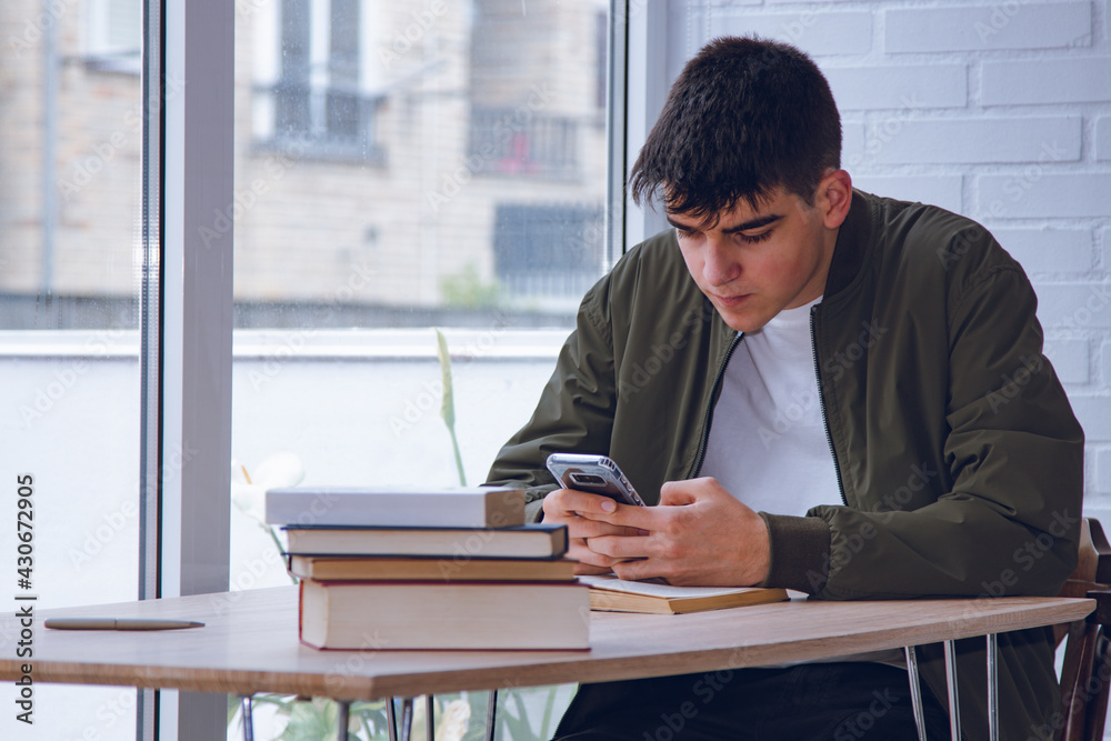 student with books and mobile phone studying at home student with books and mobile phone studying at home