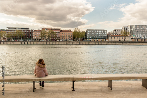 petite fille assise au bord du Rhône à Lyon devant la ville © jef 77