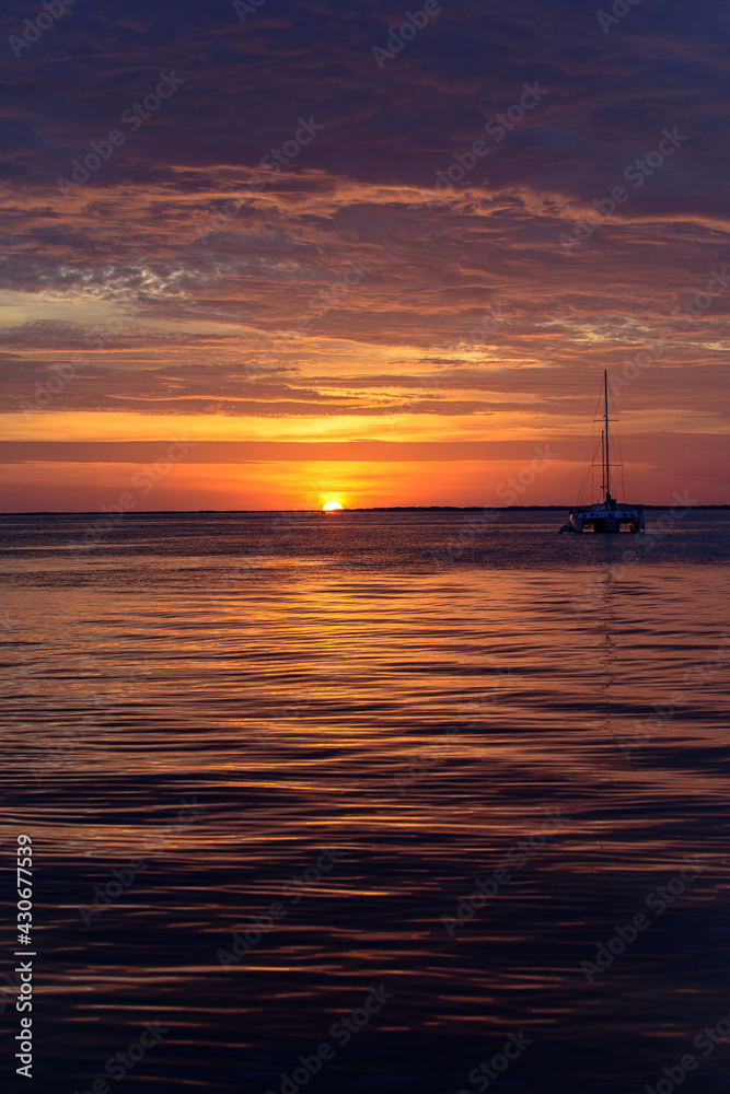 Boat on the ocean at sunset. Sailboats with sails. Sea yacht sailing along water.