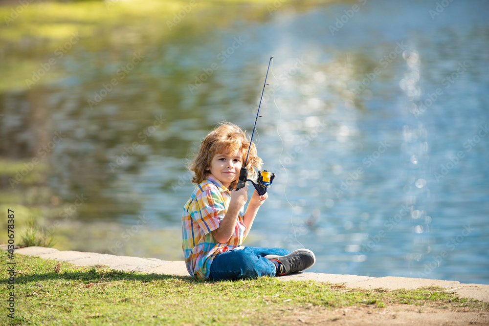 Happy childhood. Child fishing on the lake. Boy with spinner at river. Fishing concept.