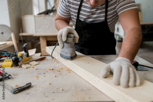 Bild auf Leinwand Man worker using electric sander in workshop