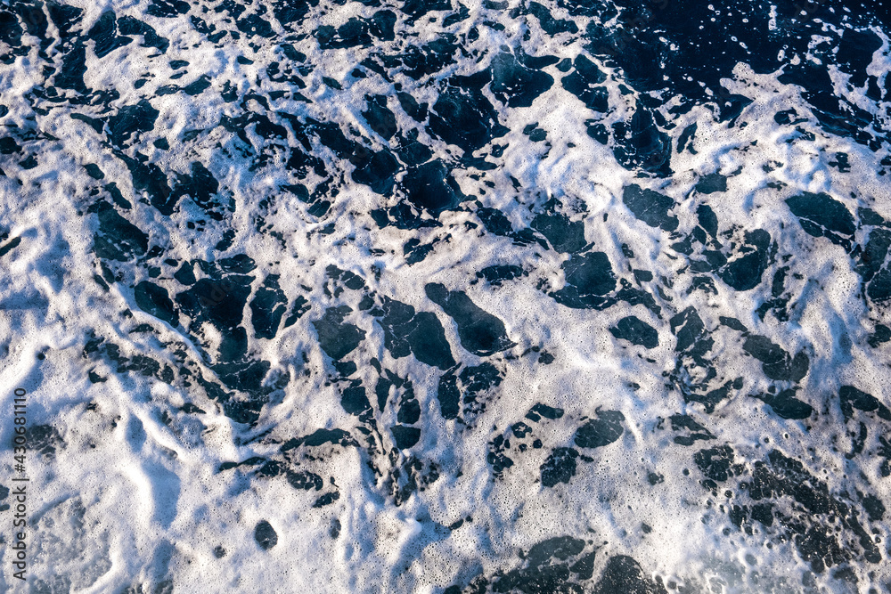 Fototapeta premium Top down aerial view of sea water surface. White foam waves texture as natural background.