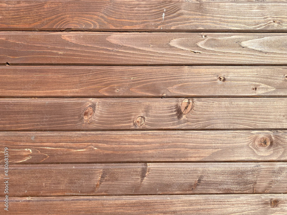 Fototapeta premium Beautiful wooden texture of horizontal multi-colored boards with knots on a brown wall surface. The background. Texture