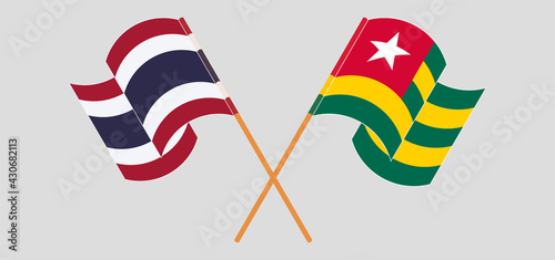 Crossed and waving flags of Thailand and Togo