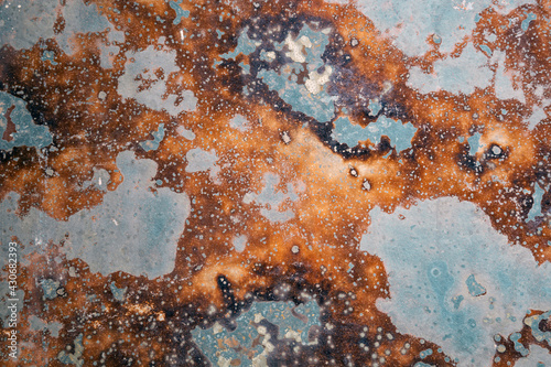 Corrosion. Vintage plate with weathered colors and rust. Spotted blue, brown and orange metal plate. Old oxidized colorful textured surface. Abstract grunge rusty metallic background for multiple uses photo