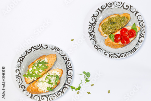 Two plates with different types of bruschetta on a white background. Overhead, Copy space, horizontal
