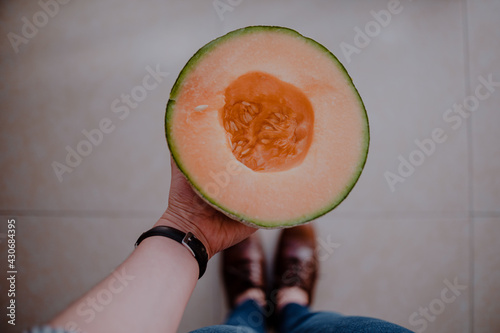 Sosteniendo un melón partido por la mitad photo