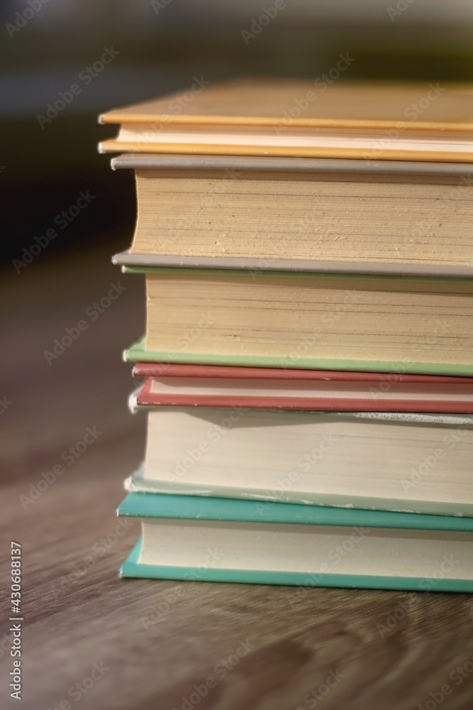 Stack of colorful books on a table. Selective focus.