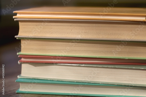 Stack of colorful books on a table. Selective focus.