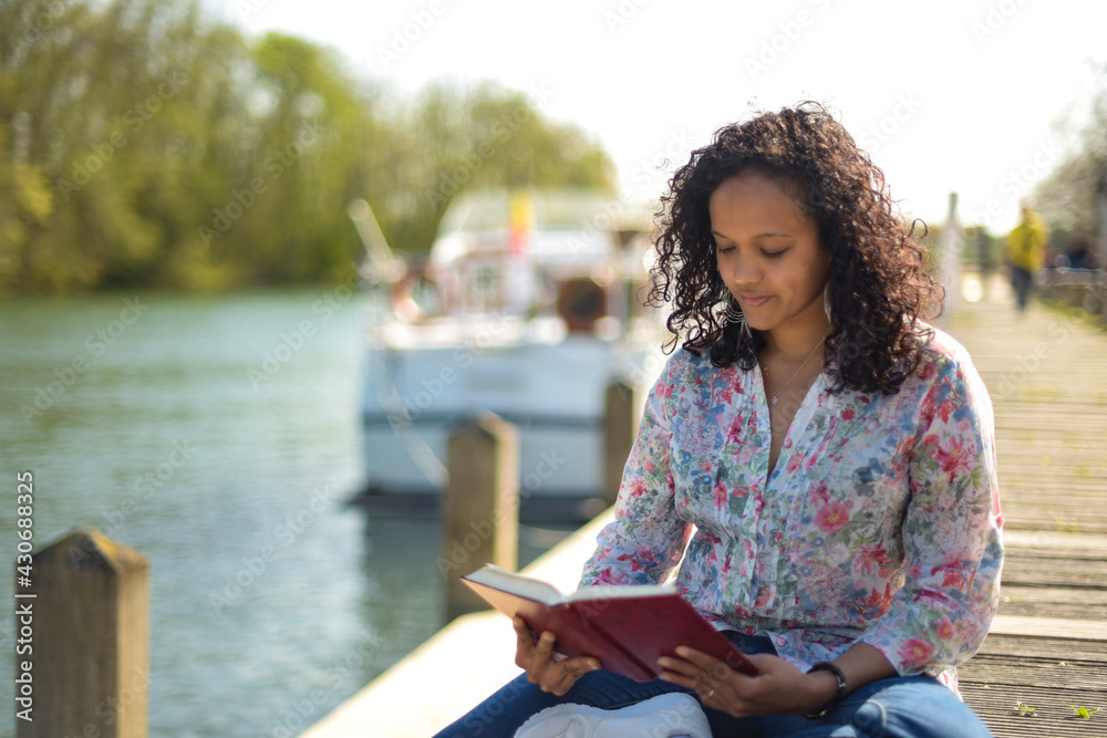 Obraz premium metis woman reading a book in a natural setting