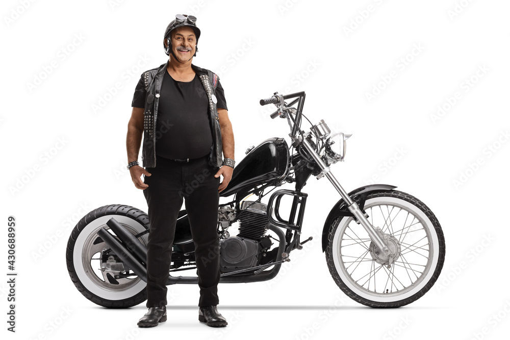 Full length portrait of an elderly biker with a leather vest and a custom chopper Full length portrait of an elderly biker with a leather vest and a custom chopper