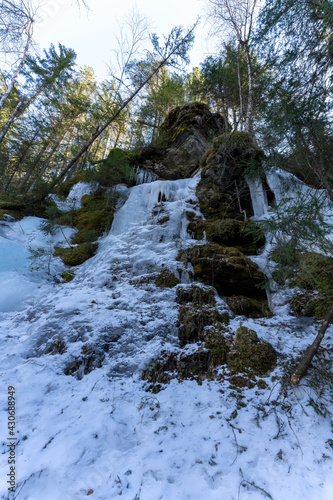 Frozen icicles on rocks in a Norwegian forest in April photo