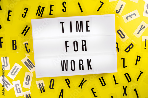 Lightbox with message TIME FOR WORK on yellow background with black letters randomly scattered. Concept of time management, deadline, overtime work, productivity, break, workaholic schedule, career