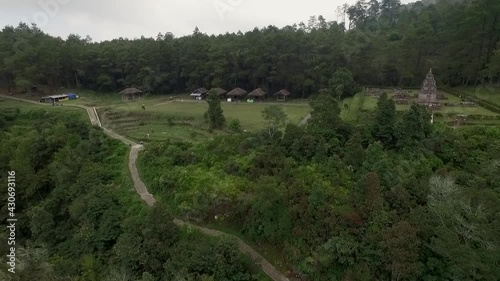 Bandungan tourist place showing isolated ancient Hindu temple and sidewalk. View from drone flying trucking movement from left to right photo