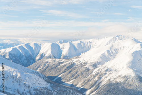 Beautiful panoramic shot of winter mountain peaks covered in snow during the winter season against the cloudy blue sky. Snowy Mountains in the city of Zakopane - Kasprowy Wierch. High Quality