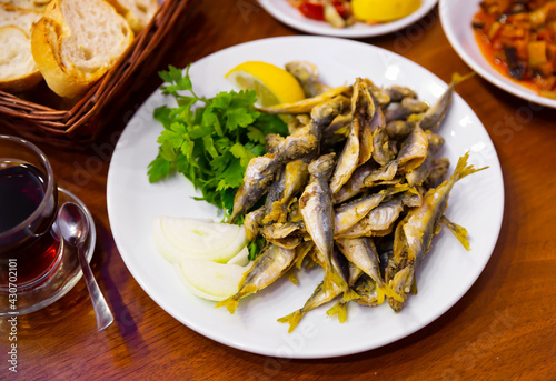 Dietary mullet fish. Fried fish in a plate with parsley and lemon. Turkish cuisine