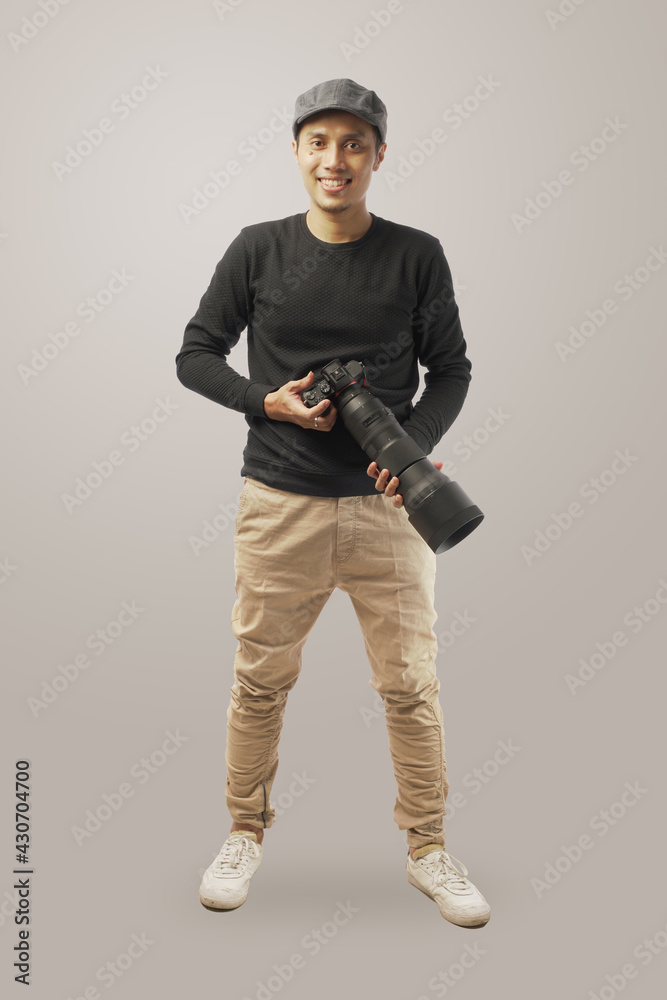 The photographer pose with holding the professional camera and tele lense isolated in white background. The photographer pose with holding the professional camera and tele lense isolated in white background.
