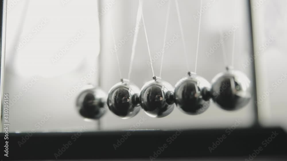 Newtons cradle in slow motion, side view Newtons cradle in slow motion, side view