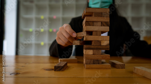 Arrange the wooden blocks stacked on the table. Construction business risk concepts For a successful business growth process