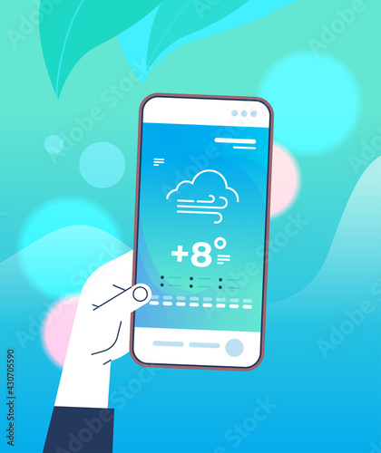 human hand holding smartphone with daily temperature mobile app weather forecasting and meteorology