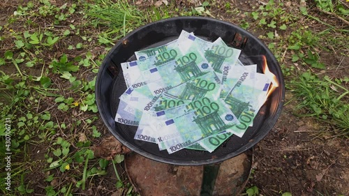 A pile of one hundred euro banknotes are burning