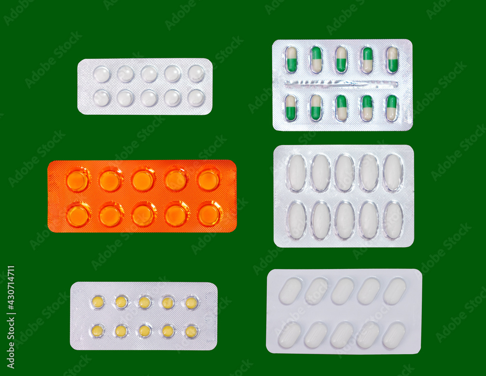 varity of tablets medicine in blisrters on isolated green background varity of tablets medicine in blisrters on isolated green background