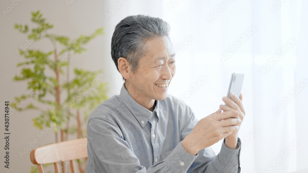 携帯電話の機種変更をするシニア男性 携帯電話の機種変更をするシニア男性