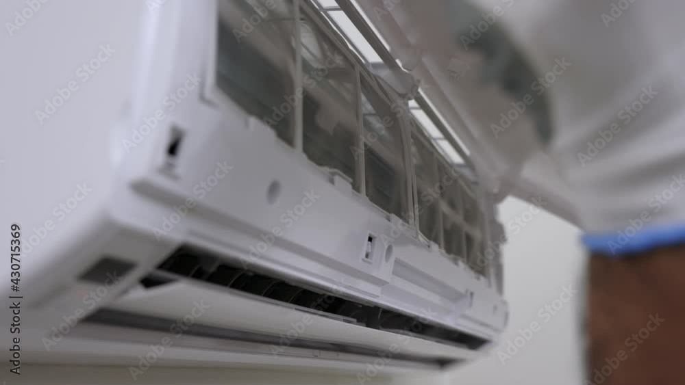 Air conditioner service indoors. Air conditioner cleaning technician He opened the front cover. Air technicians use screwdrivers to fix the air conditioner. Air conditioner service indoors. Air conditioner cleaning technician He opened the front cover. Air technicians use screwdrivers to fix the air conditioner.