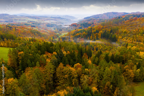 Aerial view of picturesque autumn hilly landscape with colored trees..