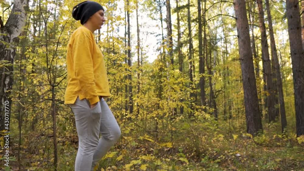 Young Woman Hiking in Forest in Autumn. Active healthy Beautiful woman in wood. Female traveler with walks along forest. Side view, Slow motion, leisure, bio-tourism. Autumnal mood Young Woman Hiking in Forest in Autumn. Active healthy Beautiful woman in wood. Female traveler with walks along forest. Side view, Slow motion, leisure, bio-tourism. Autumnal mood