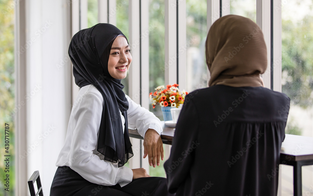 Happy Muslim female colleagues having coffee break at workplace Happy Muslim female colleagues having coffee break at workplace