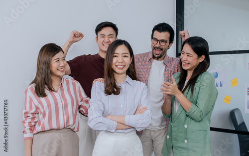 Group of mixed race people wearing casual business shirt, smiling with happiness and success, congrats and give applause to asian female leader.
